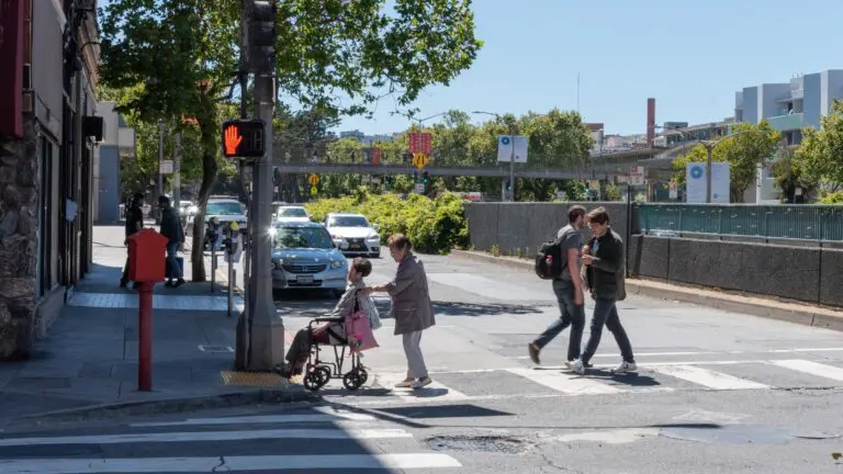 Pedestrians crossing Geary Boulevard, one of San Francisco's speed safety camera corridors, in an SFMTA photo - San Francisco