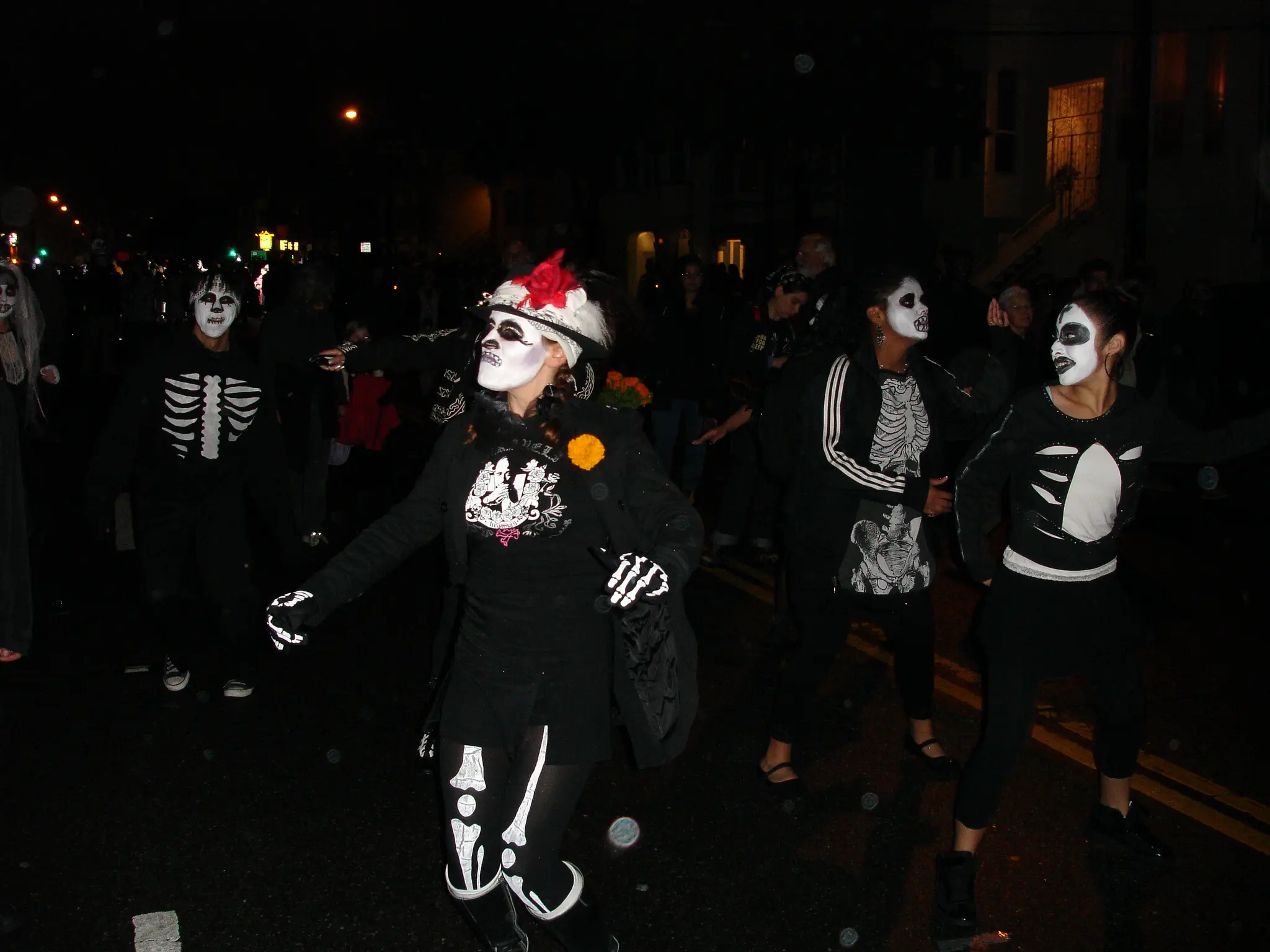 Participants in skull face paint walking in the Day of the Dead procession in the Mission District - San Francisco