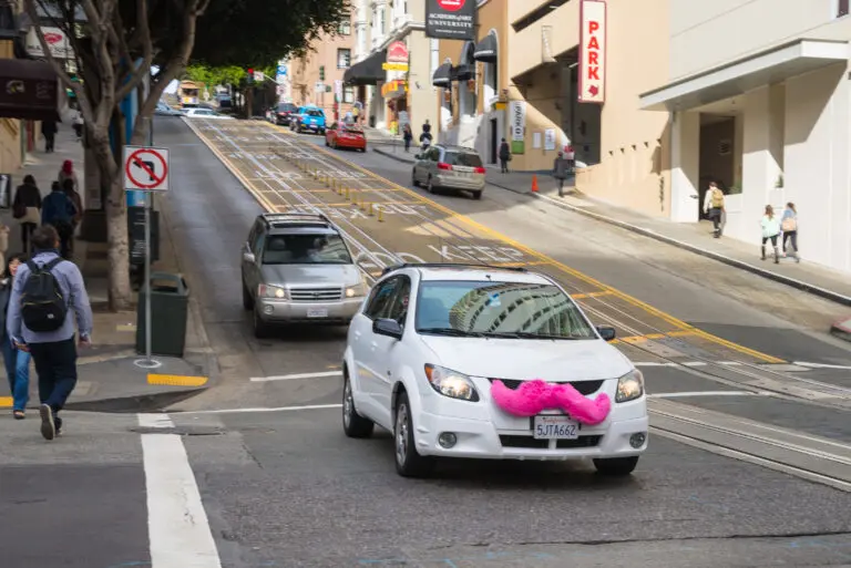 Lyft car with a pink mustache driving on Powell Street cable car tracks - San Francisco