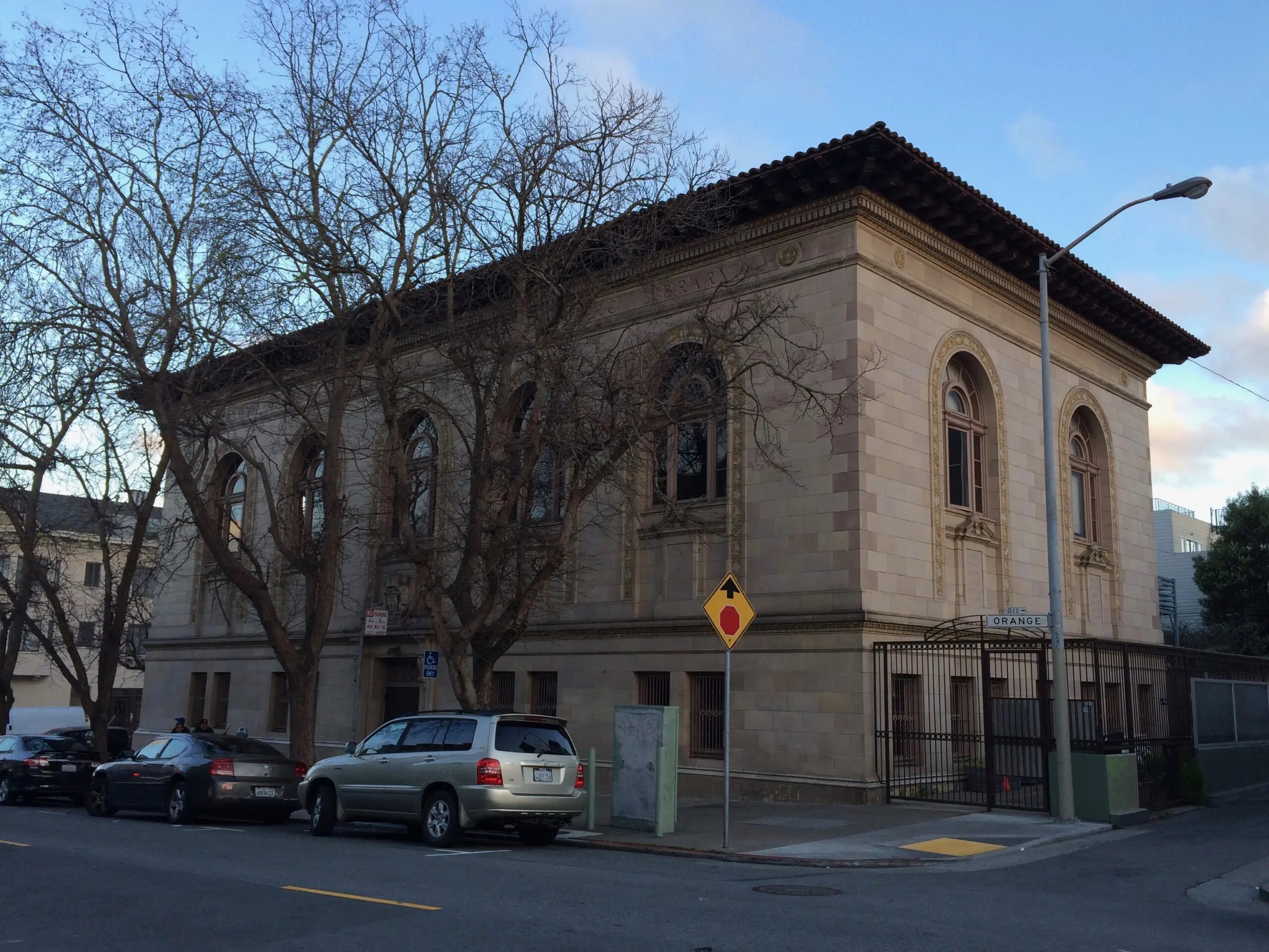 Mission Branch Library at 24th and Bartlett streets, a Carnegie-era landmark building with arched windows, seen from Orange Alley - San Francisco