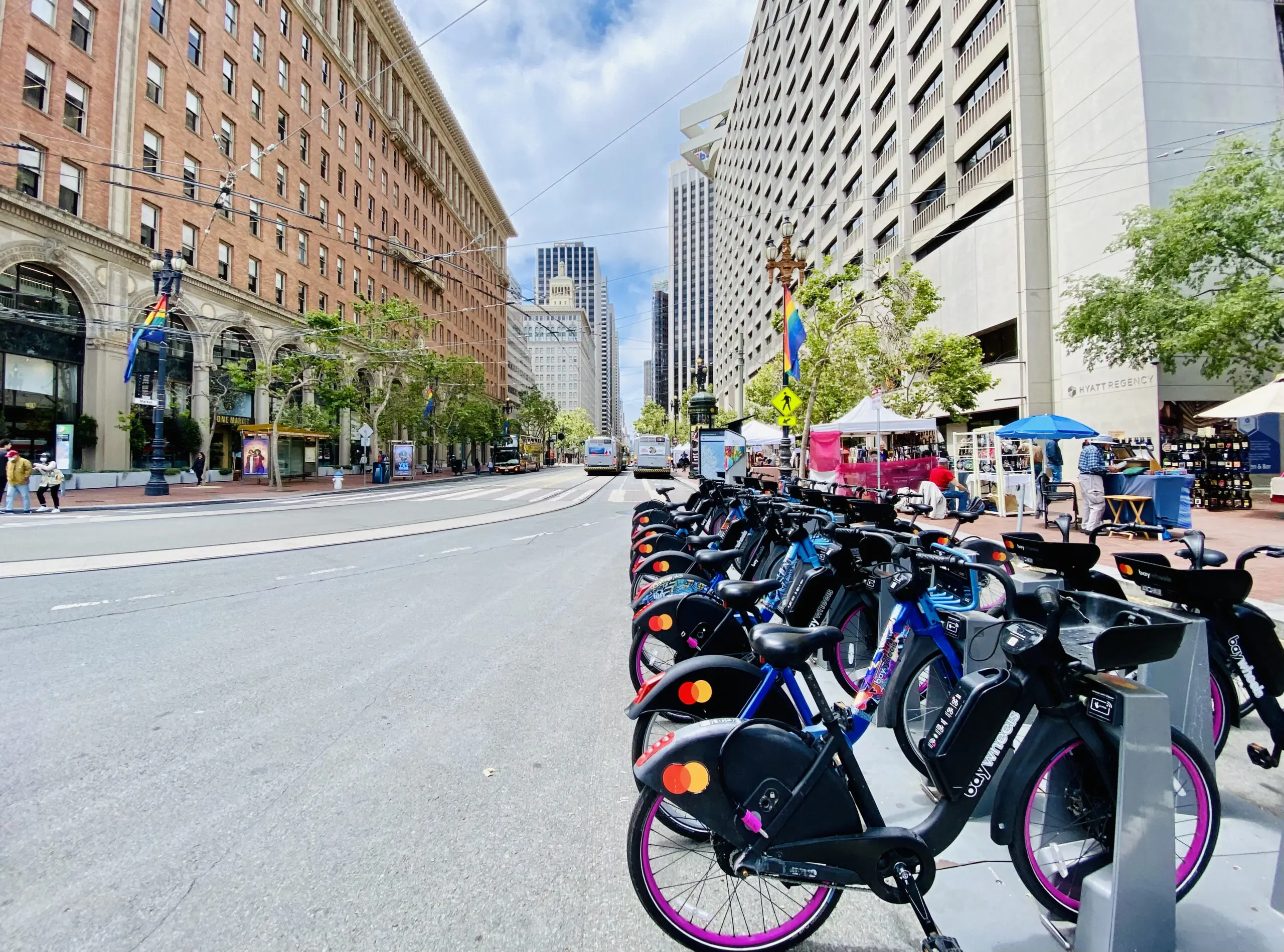 Row of Lyft Bike (formerly Bay Wheels) bikeshare bikes docked at a station on Market Street - San Francisco