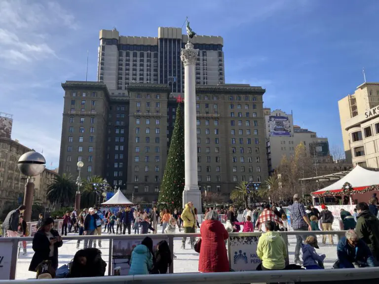 Skaters on the holiday ice rink in Union Square beside the Dewey Monument and Christmas tree, December 2022 - San Francisco