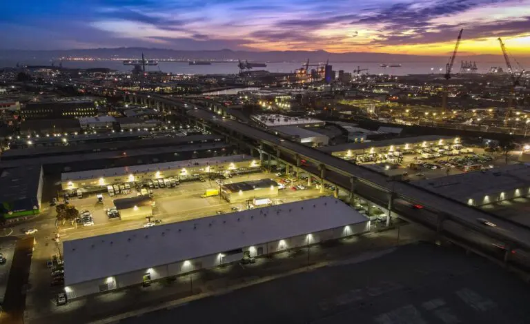 Aerial view of SF Market's wholesale produce warehouses in the Bayview before sunrise, with the bay behind - San Francisco