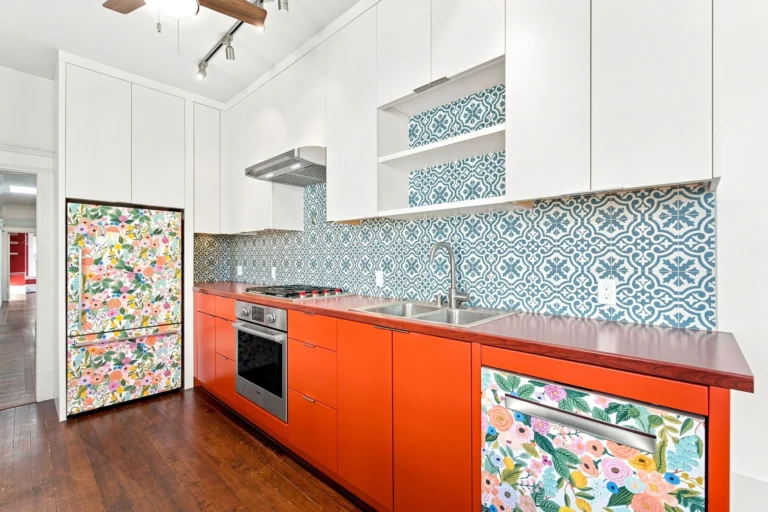 Renovated kitchen with orange cabinets and patterned blue tile in the Celadon House unit offered by Artist Space Trust in the Mission District - San Francisco